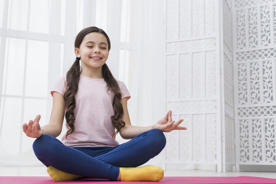 Niña practicando yoga en casa