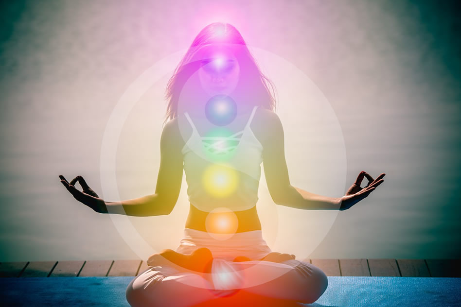Mujer practicando yoga con los chakras activados poniendo conciencia en ellos